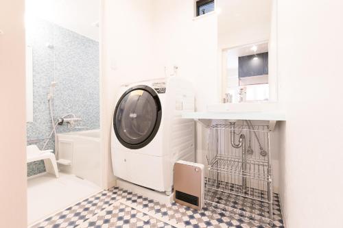 a bathroom with a toilet and a sink and a tub at Guesthouse Tonton Nobu in Kyoto