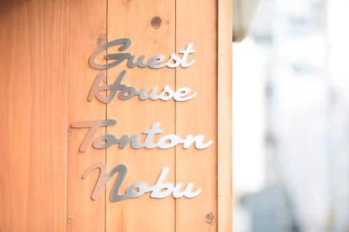 a sign on the side of a wooden door at Guesthouse Tonton Nobu in Kyoto