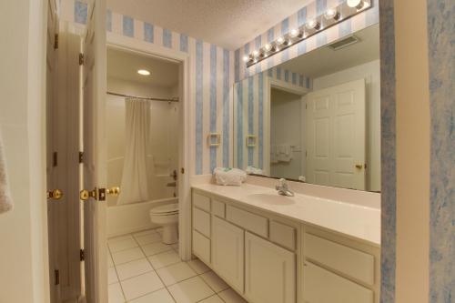 uma casa de banho com um lavatório, um WC e um espelho. em The Enclave #801 em Orange Beach