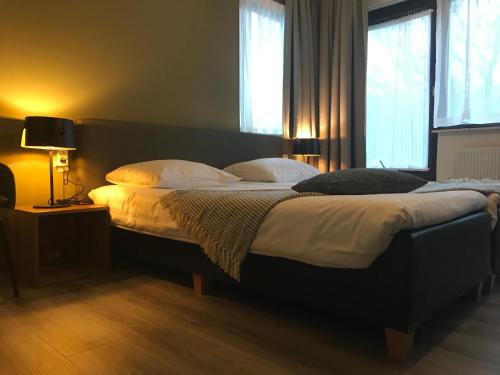 a bedroom with a large bed with white sheets and pillows at Bed & Breakfast Van Marion in Oostvoorne
