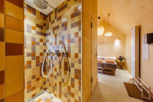 ein Bad mit einer Dusche mit gelben und braunen Fliesen in der Unterkunft Haus am Schilf in Wieck