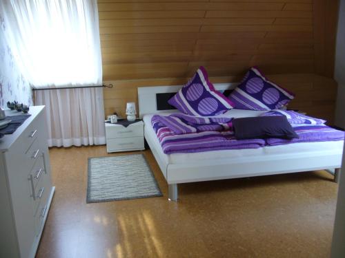 a bedroom with a bed with purple pillows at Ferienwohnung Waldblick in Munster im Heidekreis