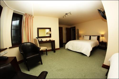 a bedroom with a bed and a desk and a chair at All the Twos Lodge in Clifden