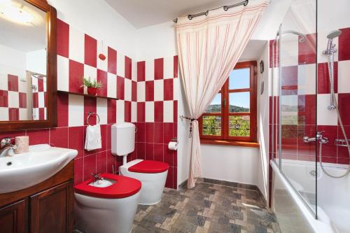 ミルナにあるVilla Vicina Heritage villa for 9,Milna - close to restaurants and shopsの赤と白のバスルーム(トイレ、洗面台付)