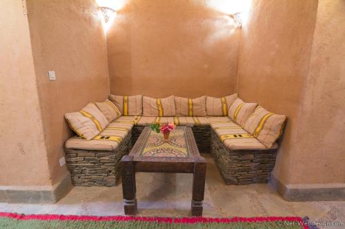 a living room with a couch and a table at Kasbah Imdoukal in Nkob