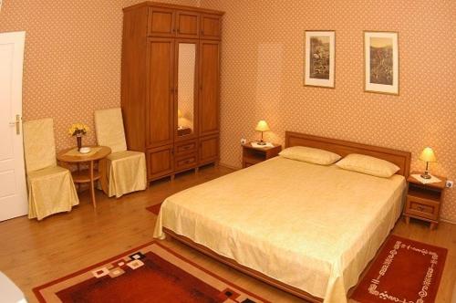 a bedroom with a bed and two tables and two chairs at Peron Panzió in Debrecen