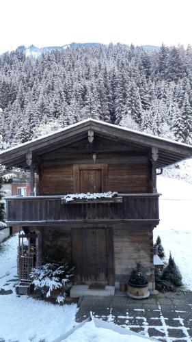 a log cabin with snow on the roof at Nieslerhof in Mayrhofen