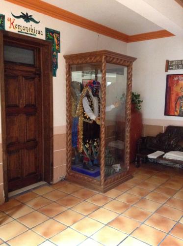 a room with a large glass cabinet in the corner at Hotel Regis in Uruapan del Progreso