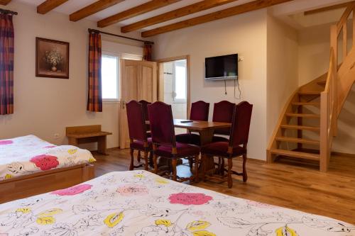 a bedroom with a table and chairs and a room with a staircase at Relais du Klevener in Heiligenstein