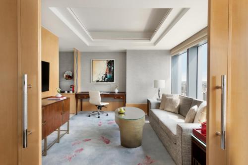 
a living room filled with furniture and a large window at Jing An Shangri-La, Shanghai in Shanghai
