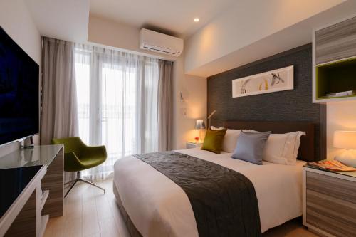 a hotel room with a large bed and a television at Oakwood Apartments Minami Azabu Tokyo in Tokyo
