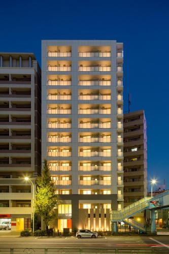a tall building with lights on in a parking lot at Oakwood Apartments Minami Azabu Tokyo in Tokyo