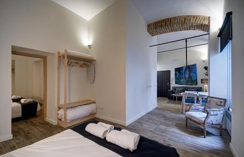 a room with a bed and a living room at Apartamentos AL-QAZERES LUXURY La Concepción in Cáceres
