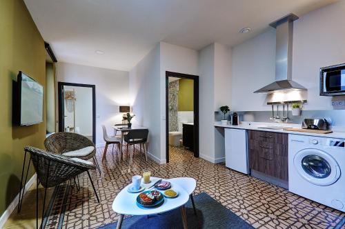a kitchen and living room with a washer and dryer at Apartamentos AL-QAZERES LUXURY La Concepción in Cáceres
