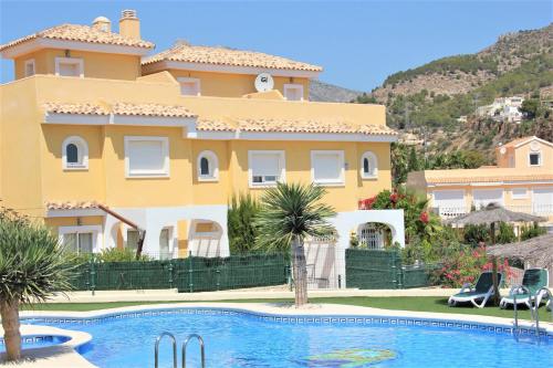 a large yellow house with a swimming pool in front of it at MONTESOL28 in Calpe