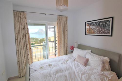 a bedroom with a bed and a large window at MONTESOL28 in Calpe