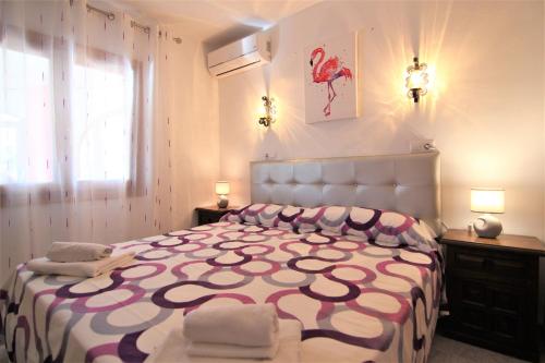 a bedroom with a large bed with a pink and white bedspread at ACAN0306 in Calpe