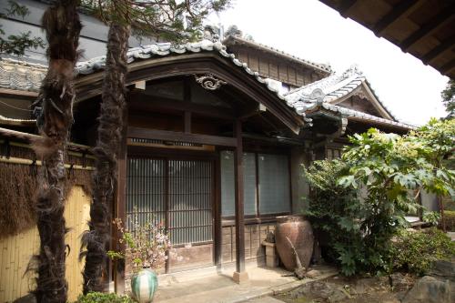 an asian house with a gate and a tree at 丹徳庭園 in Kawagoe