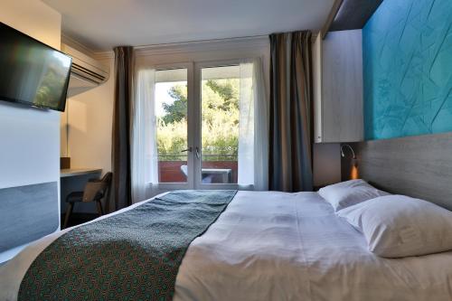 um quarto com uma cama grande e uma janela em Hotel SPA Plage St Jean em La Ciotat