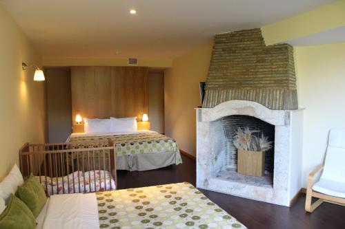 um quarto de hotel com lareira e cama em Hotel Da Montanha em Pedr�g�o Pequeno