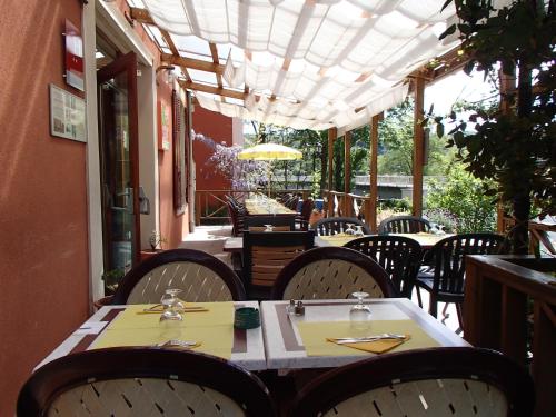 une salle à manger avec des tables et des chaises sur une terrasse dans l'établissement Hôtel restaurant de l'Île, à Jumeaux
