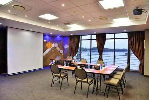 a conference room with a table and chairs and a screen at BON Hotel Waterfront Richards Bay in Richards Bay