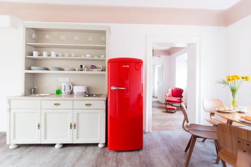 a red refrigerator in a kitchen with a table at Barbo Palace Apartments and Rooms in Ljubljana