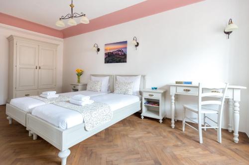 a bedroom with a white bed and a desk at Barbo Palace Apartments and Rooms in Ljubljana