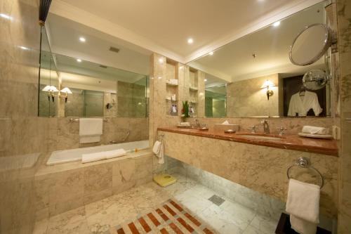 a bathroom with a tub and a sink and a mirror at Kabul Serena Hotel in Kabul