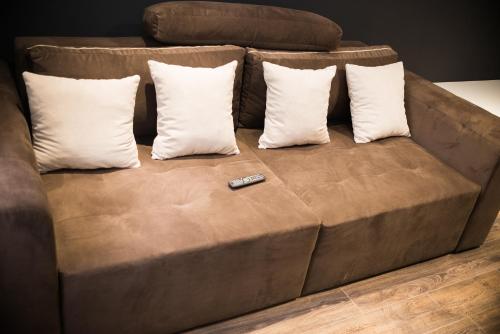a brown couch with pillows and a remote control on it at Modern apartment in Lviv