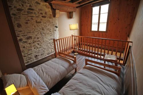 Un dormitorio con dos camas en una habitación con ventana. en La Rapiette de Noblat, en Saint-Léonard-de-Noblat