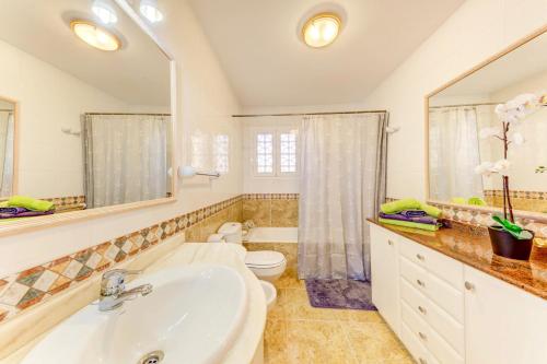 a bathroom with a sink and a toilet and a mirror at Can Gelaberts by Sealand Villas in Muro