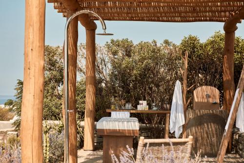 a patio with a table and chairs under a pergola at Diles & Rinies in Tinos Town