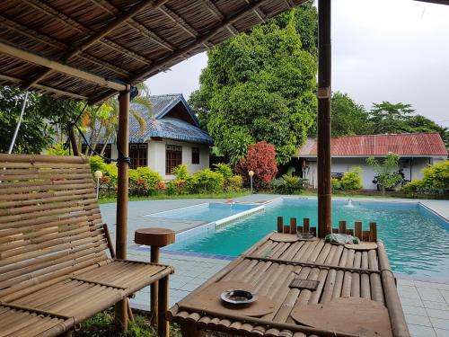 a patio with a table and chairs next to a pool at Sendowan Baru Amurang in Amurang