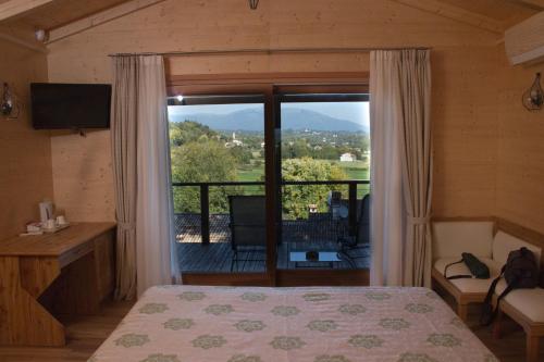 a bedroom with a bed and a large window at Country House Barone D'Asolo in Asolo