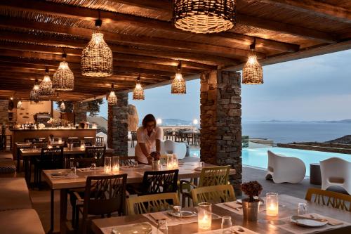 a woman standing in a restaurant with tables and chairs at Diles & Rinies in Tinos Town