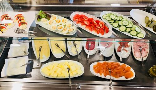 une vitrine remplie d'assiettes de fromages et de légumes dans l'établissement Hotel Café Wahlde Restaurant, à Grapperhausen