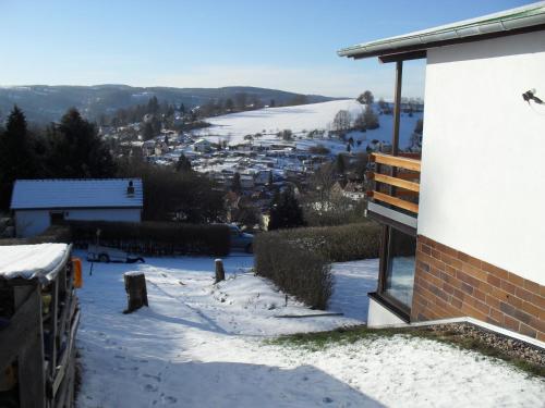 a snow covered hill with a town in the distance at Haus Gieselsberg, mit Aussicht auf Schmalkalden in Schmalkalden