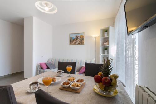 斯塔布魯克的住宿－Apartment La Mare，餐桌,包括一碗水果和饮料