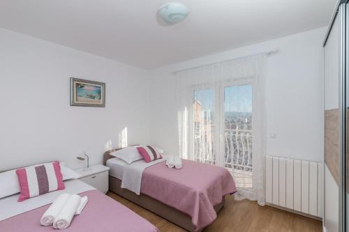 斯塔布魯克的住宿－Apartment La Mare，白色的客房设有两张床和窗户。