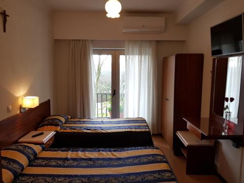 a hotel room with a bed and a window at Residencial Coroa D'Ouro in Fátima