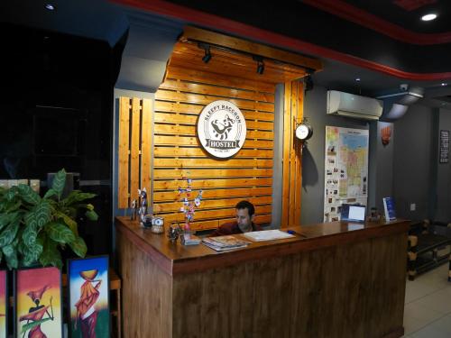 a woman sitting at a counter in a restaurant at Sleepy Raccoon Hostel in Jakarta