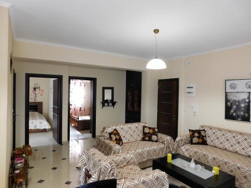 a living room with two couches and a bedroom at Eleni Apartment in Pigi