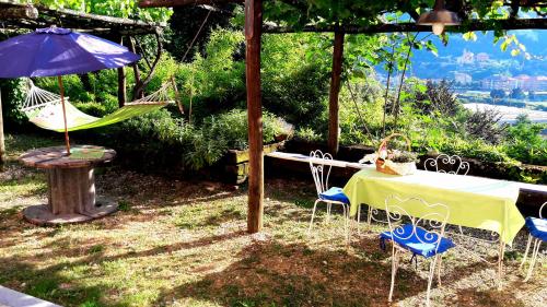 a table and chairs and an umbrella and a hammock at The italian riviera in San Salvatore