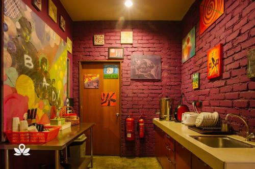 cocina con fregadero y pared de ladrillo en The Explorers Guesthouse and Hostel en Kuala Lumpur