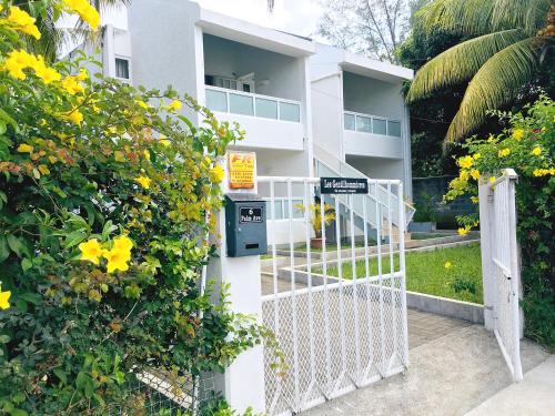 a white gate in front of a building at Les Gentilhommieres Guest House in Trou aux Biches