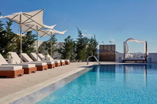 a swimming pool with lounge chairs next to a pool at 18 Grapes Hotel in Agios Prokopios