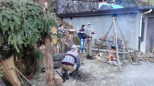 a group of people standing around a fire at casa del cirillo in Ornica