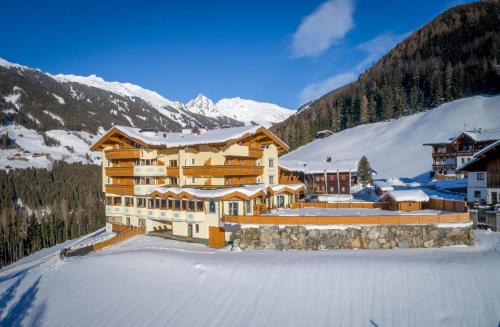 a large building in the mountains with snow on the ground at Gasthof Tannen - Alm in Stummerberg