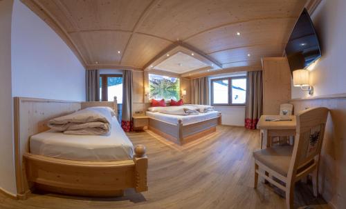 a bedroom with a bed and a desk in a room at Gasthof Tannen - Alm in Stummerberg